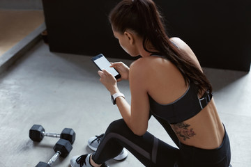 Sports Woman In Fashion Sportswear Using Phone On Training