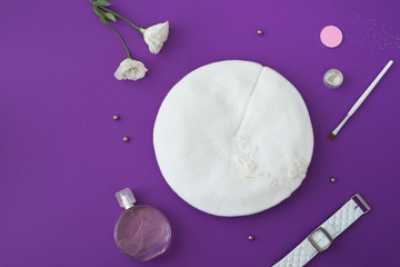 Knitted hat with decor on lilac background