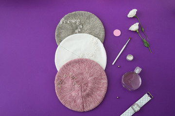 Knitted hats with decor on lilac background
