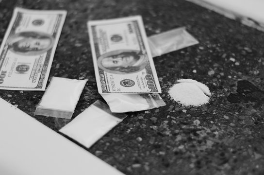 Concept: the Asian men are buying-selling drugs with dollars."International Day against Drug Abuse and Illicit Trafficking"