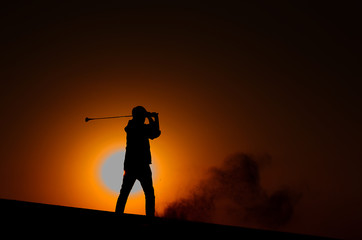 Fototapeta na wymiar Silhouette golfer man with dark light of sunset