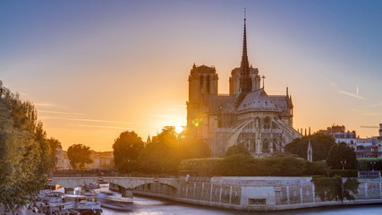 Rear view of Notre Dame De Paris cathedral at sunset with sun in the frame timelapse.