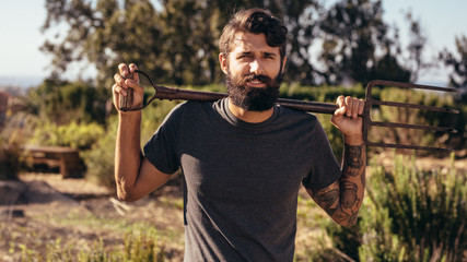 Beard man with pitchfork on farm