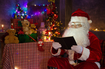 Santa Claus reading a notebook to prepare gifts for Christmas