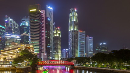 Fototapeta na wymiar A view of Singapore business district skyscrapers in the night time with water reflections timelapse hyperlapse