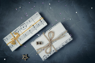 Gifts wrapped in paper with the image of music. Christmas holiday, womens day for the musician.