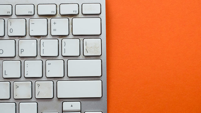 Top view white keyboard on orange background