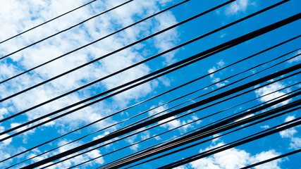 Wires and blue sky background with sun