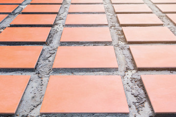 row tile ceramic orange on floor install with cement in work construction renovation outdoor home