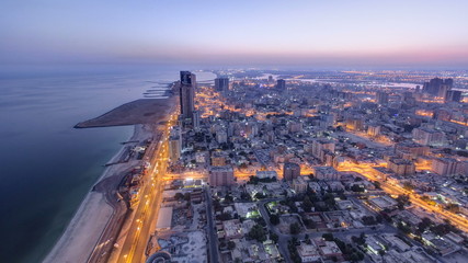 Fototapeta na wymiar Cityscape of Ajman from rooftop night to day timelapse. Ajman is the capital of the emirate of Ajman in the United Arab Emirates.