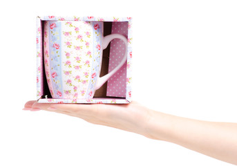 Cup mug vintage pink blue flower print box in hand on white background isolation