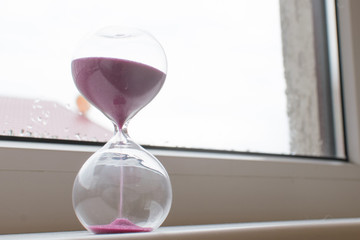 Hourglass with pink sand.