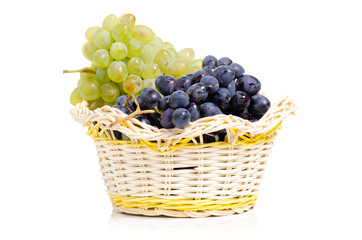 Black and white grapes in a basket on a white background isolation