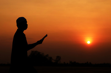 Fototapeta premium Silhouette Muslim men are chanting the light of sunset