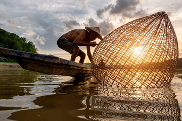 Fishermen fishing in the early morning golden light,fisherman fishing in Mekong River...