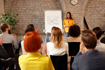 Businesswoman presenting chart to coworkers.