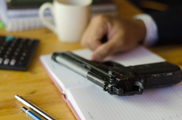 Fototapeta na wymiar The gun on the desk of a businessman