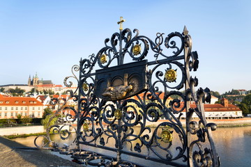 Decorative lattice with John of Nepomuk bronze statue on Charles Bridge, Prague, Czech Republic, sunny day