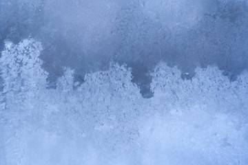 Graceful wavy winter frosty icy pattern similar sea foam on window pane.