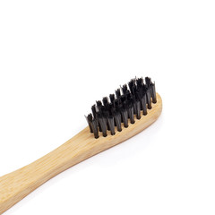Black nylon bristles closeup on bamboo wooden toothbrush isolated on white background