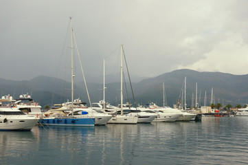 Naklejka premium Misty Mediterranean landscape. Yachts in the fog. Montenegro, Adriatic Sea, Bay of Kotor, Tivat city. View of yacht marina of Porto Montenegro