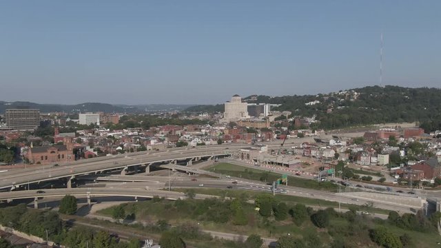 A high angle forward moving aerial establishing shot of Pittsburgh's North Side district. Allegheny General Hospital seen in the distance, traffic on I-279 in the foreground.  	