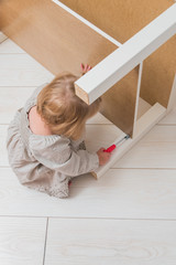 girl, child collects a new table, on backdrop of a white brick wall