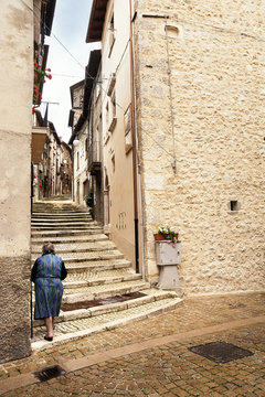 Staircase with a grandmother in the historic center of Scanno (Italy)