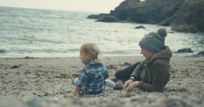 Young woman and toddler sitting on the beach