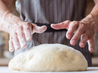 bakery and homemade bread. food preparing and cooking skills concept. man hands ready to knead dough.