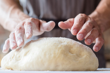 breadmaking process. food cooking and culinary skills concept. man hands ready to knead dough.