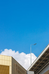 The abstract background with the blue sky and the cloud, building's walls and the lamp post at the bottom