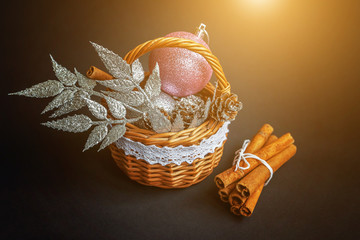 Christmas New Year composition with balls pine cones cinnamon sticks in basket black background. Xmas holiday december decoration to Russian tradition