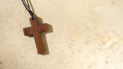 Religiöses Kreuz liegt auf einer gelben Steinplatte