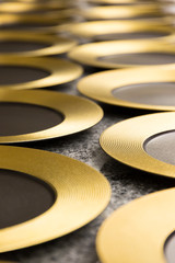Gold rimmed round plates laid out on a restaurant table preparing to be used for dinner.