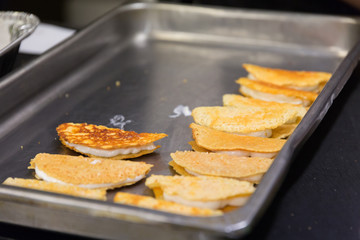 A pile of Taco shells in a restaurant to be used in a gourmet dinner.