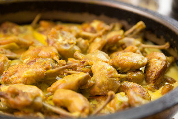A plate of Chicken pieces cooked in a pan in a restaurant kitchen.