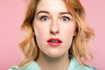 Naklejka premium surprised startled astonished amazed girl with open mouth. unbelievable news. young beautiful woman on pink background. emotional facial expression.