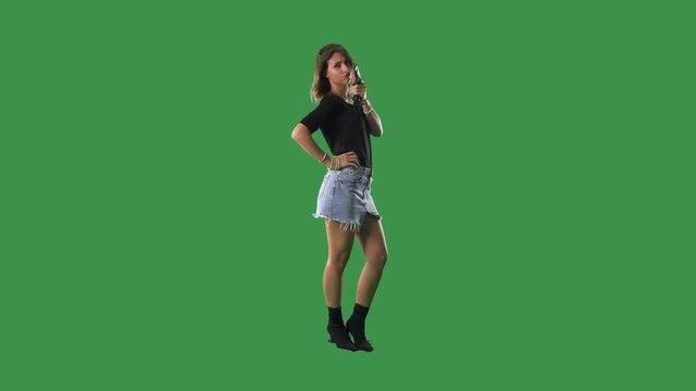 Dangerous sexy bad woman holding and posing with handgun. Full body isolated on green screen background. 