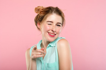 emotion and facial expression. flirty coquettish woman pleased with herself smiling and winking at...