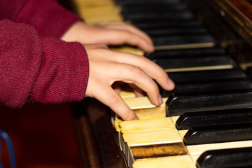 Fototapeta premium little hands playing an old piano