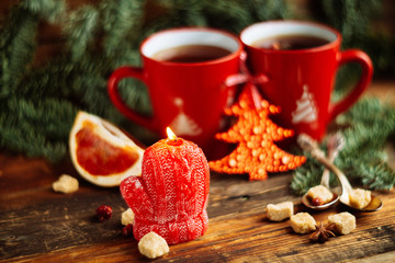 Christmas composition. Christmas cake pan de pasqua, red mug of tea and Christmas New Year decoration - fir brunches, fir and pine cones, New Year balls, red napkin on black background