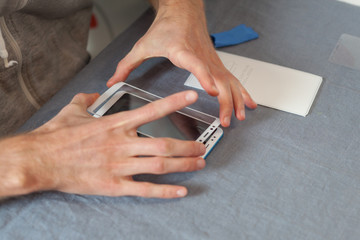 Preparing the phone to replace the screen concept. High angle top view cropped photo man is holding...