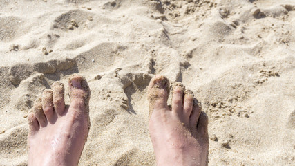 nasse nackte Füße in Strandsand