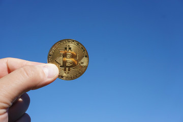 Bitcoin wird mit 2 Fingern in den Himmel gehalten