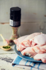 chicken breast, potatoes, onions, tomatoes - raw ingredients for making baked chicken breast with vegetables, vintage pan on a light wooden background