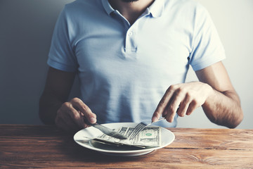 Hands cut money on plate reduce funds concept