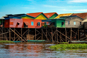 Colorful, multicolored stilt houses line the edge of Lake Tonle Sap in the floating village of Kampong Khleang, near Siem Reap in Cambodia