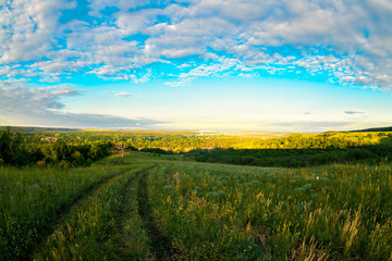 Obraz premium Russian vastnesses. Field road at sunset. Sunset in the field. Place - Middle Don, Russia, Liski Area of Voronezh Region