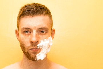 Half the face of the man in the shaving foam. Concept morning of a man.